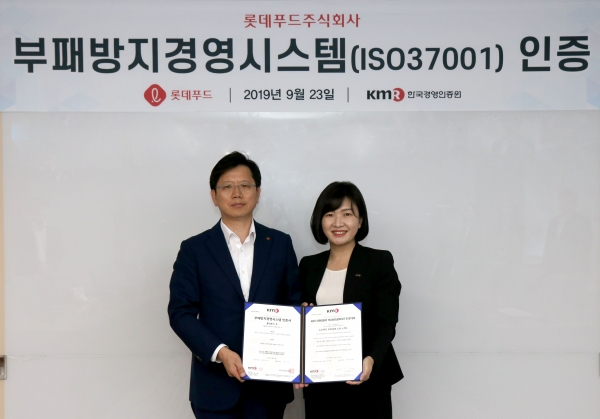 23일 롯데푸드 본사에서 진행된 ISO 37001 인증 수여식에서 롯데푸드 김재열 홈푸드사업본부장(왼쪽)과 한국경영인증원 황은주 대표이사(오른쪽)이 인증서를 들고 사진을 찍고 있다.