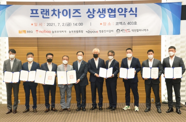 문승욱 산업부 장관(가운데), 정현식 프랜차이즈협회장 및 각 브랜드 가맹본부-가맹점단체 대표들이 상생협약식을 기념하고 있다